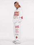 Person wearing a white hoodie and pants with text and red cross symbols on a white background