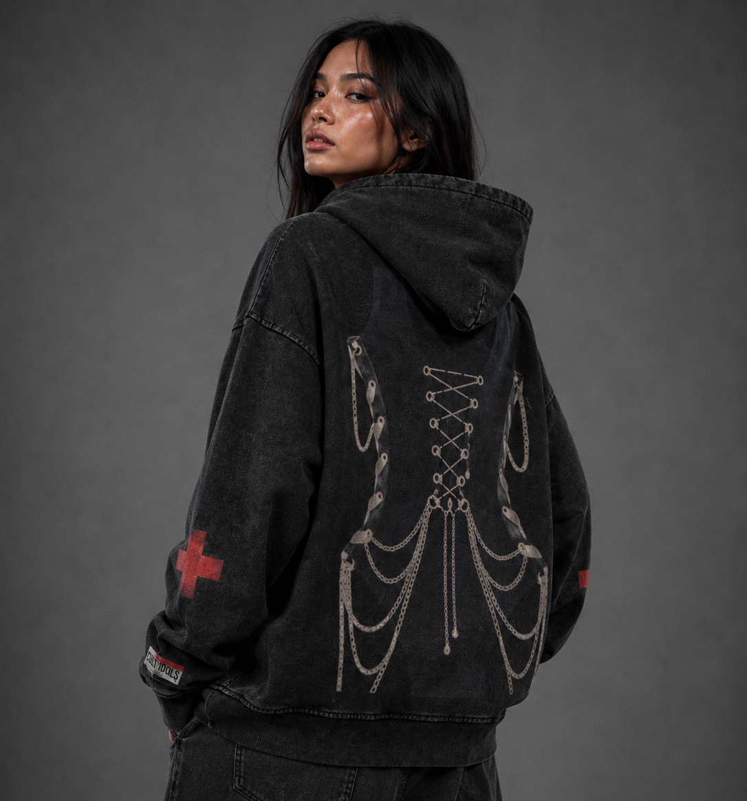 Person wearing a black hoodie with intricate designs and text on a gray background
